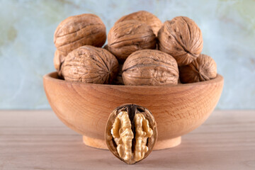 Walnut kernels and cracked walnuts on wooden background, front view