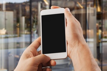 Hands hold a phone with a blank screen