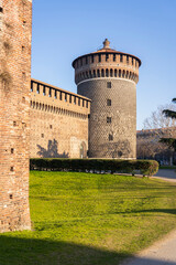A fragment of the facade of the castle with tower at sunny day in Milan, Italy