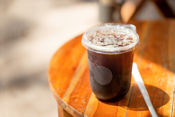 Glass of iced americano coffee on wooden table