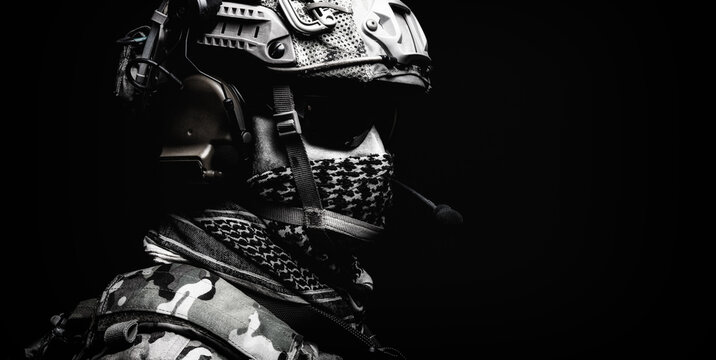 Modern army special forces equipped soldier, anti terrorist squad fighter, elite mercenary in helmet, studio portrait in darkness. Close up, half length