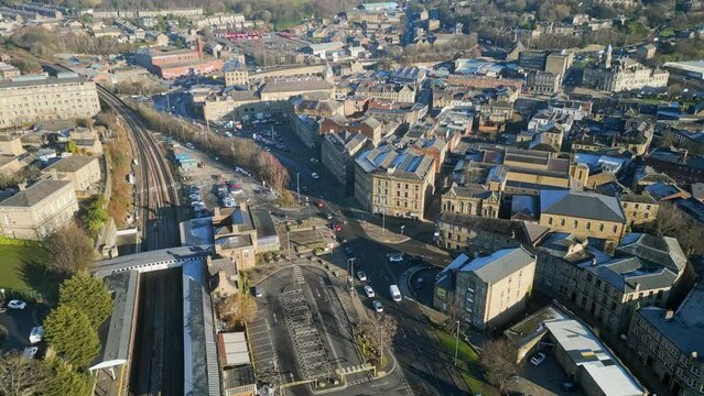 Busy urban UK town in Yorkshire. Showing train station, roads, train railway tracks. Cinematic aerial footage.