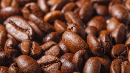 Freshly roasted coffee beans background.Dark roasted coffee beans with scoop on wooden background.