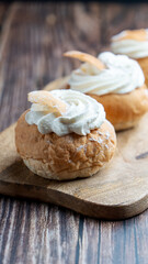 Semla, fastelavnsbolle, fastlagsbulle. Decorated with an Estonian flag. On a wooden table with a dark background.