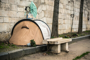 Homeless man in a tent near the wall on the river bank in Paris France. Life on the street. Homeless life. When you don't have your own home and job. The life of a poor man. Homeless man in a tent