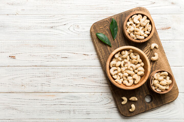 Fototapeta na wymiar cashew nuts in wooden bowl on table background. top view. Space for text Healthy food