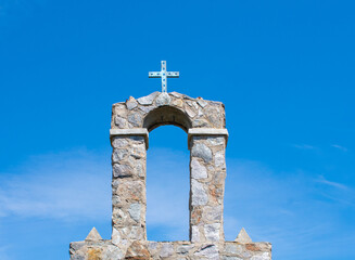 Fototapeta na wymiar christian cross on top of the stone bell tower