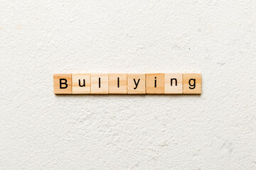 Bullying word written on wood block. Bullying text on cement table for your desing, concept
