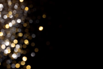 Golden and silver blurred bokeh lights on black background. Glitter sparkle stars for celebrate. Overlay for your design