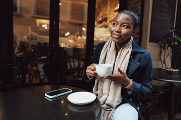 Stylish young african woman at cafe having coffee