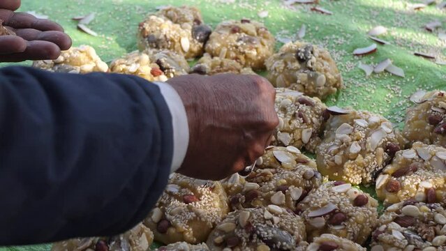 Hand Placing Nuts Onto Row Of Jaggery Lumps