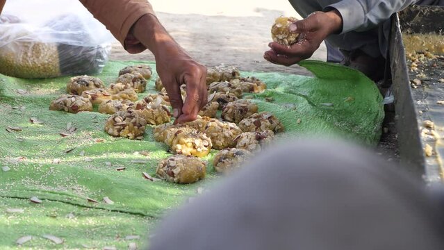 Hand Placing Nut Onto  Freshly Made Jaggery Lumps