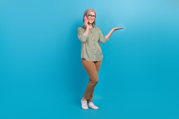 Full body size photo of business lady hold palm empty space proposition high profit offer talk employee phone isolated on blue color background