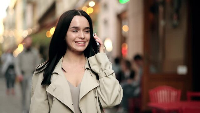 Woman smiling confident talking on the smartphone at street