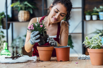 Influencer woman arranging plants and flowers while recording a tutorial video with smartphone in a...
