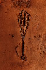 Wisk pattern in cocoa powder. Food art cocoa and wisk stamped print.