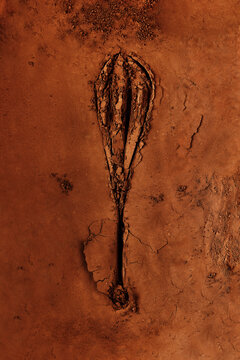 Wisk pattern in cocoa powder. Food art cocoa and wisk stamped print.