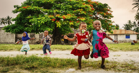 Group of African Little Children Running Towards the Camera and Laughing in Rural Village. Black...