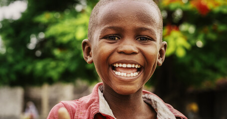 Close Up Portrait of an Expressive Authentic African Kid Laughing and Looking at the Camera Blurry...