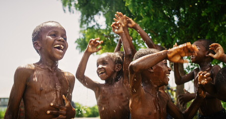 Group of Happy and Innocent Black Children Playing and Enjoying the Blessing of Rain Water After...