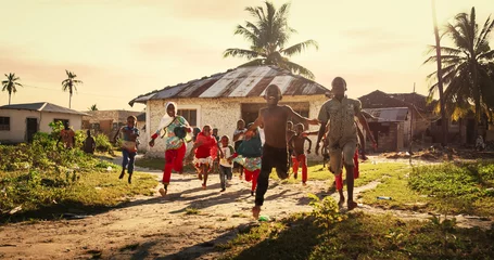 Foto op Plexiglas Zanzibar Group of African Little Children Running Towards the Camera and Laughing in Rural Village. Black Kids Full of Life and Joy Enjoying their Childhood and Playing Together. Little Faces with Big Smiles