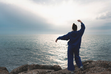 Beautiful young woman outdoors at sea enjoying freedom. Wanderlust concept.