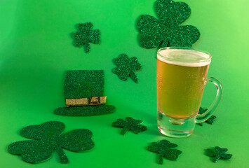 Beer mug on green background with shamrock and sombrero, saint patrick's day