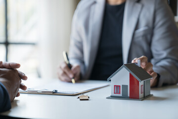 Young Asian home sales agents, insurance agents, and real estate agents offer young Asian entrepreneurs information on price conditions when signing a contract to buy rent house in the office.