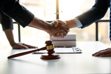 Legal and justice concept Young asian businessman shaking hands with young lawyer or legal advisor after contracting business partnership agreement in real estate project and finance in the office.