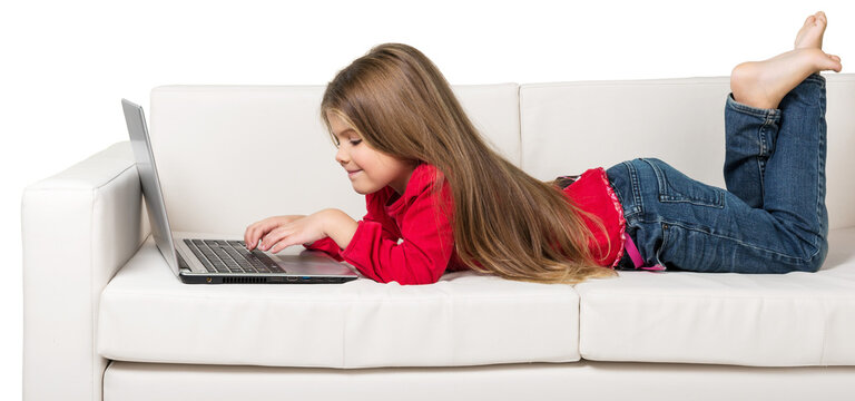 Cute little girl using laptop on sofa isolated on white background