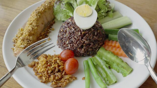 Fried salmon fish with riceberry (Riceberry is a rice variety from Thailand) and vegetable, healthy food style.
