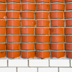 Individual design of red brick wall from diagonally angular bricks close up. Geometric background...