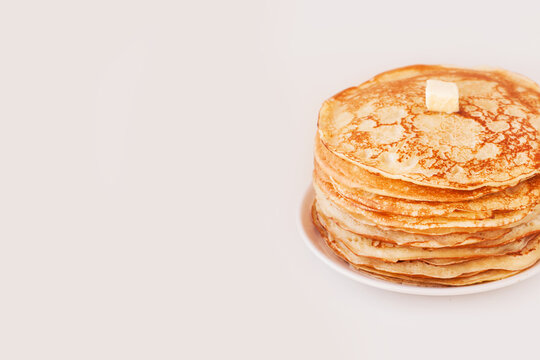 Staple of yeast fluffy pancakes with butter. Spring holiday Traditional Russian Shrovetide Maslenitsa week or pancake tuesday holiday. american crepes isolated on white gray background. side view