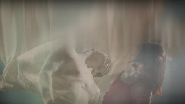 Art dance moves with long fabrics . Few shots of the powerful psychological contemporary ballet dancing movements with large textile materials . People dancing , flying , jumping . Growth of cloth