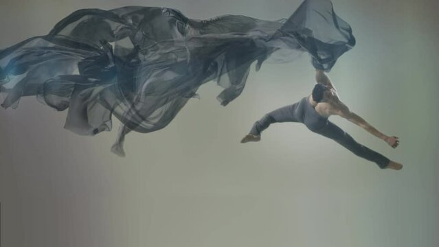Art dance moves with long fabrics . Few shots of the powerful psychological contemporary ballet dancing movements with large textile materials . People dancing , flying , jumping  . Growth of cloth