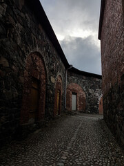 Dark alley between stone buildings in Suomenlinna, Helsinki