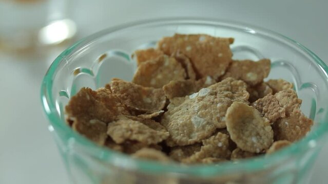 Conflake ingredients food in glass bowl on white table, panning camera