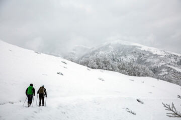 Fototapeta na wymiar Hikers tourist in the white snowy mountain hike in the forest