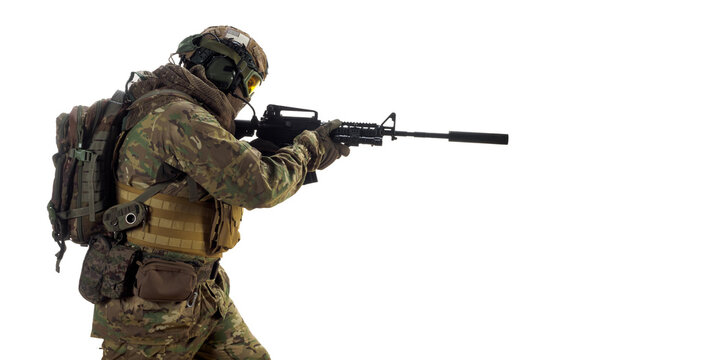 Mercenary soldier with an automatic rifle in his hand aiming in enemy.