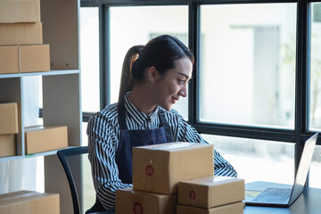 An Asian businesswoman enjoys his online SME business selling products, profiting from opening an...