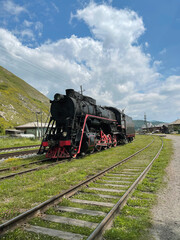 Fototapeta na wymiar Vintage steam locomotive drives away from the station, Port Baikal, Russia
