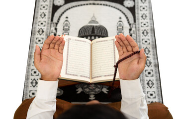 Naklejka premium Muslim man raises his hand for prayer with background of the Quran