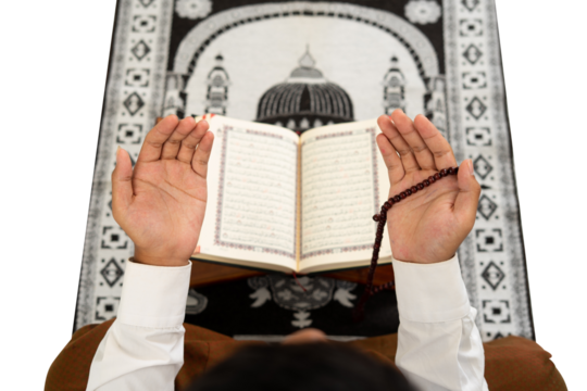 Muslim man raises his hand for prayer with background of the Quran