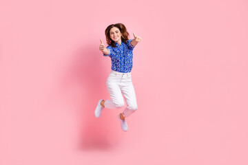 Full length photo of cute excited lady wear print shirt jumping high showing thumbs up isolated...