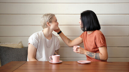 Elegant lesbian couple in t-shirts talks looking into eyes