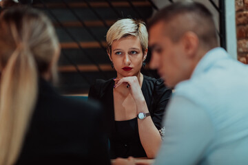 Happy businesspeople smiling cheerfully during a meeting in a coffee shop. Group of successful business professionals working as a team in a multicultural workplace.