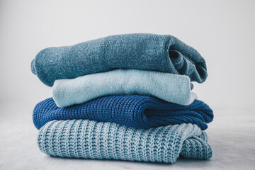 Sweaters. Blue sweaters stacked on gray background.
