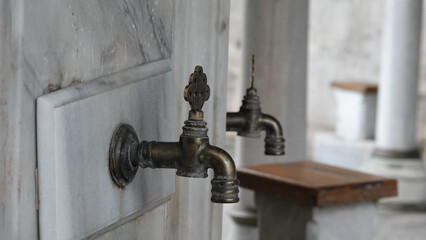 A historical public ablution place in the courtyard of the Ottoman Mosque. Close Up View of Ablution Fountains and stools.  Ramadan prayer background.