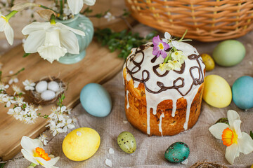 Obraz na płótnie Canvas Happy Easter! Homemade easter bread and natural dyed easter eggs with spring flowers on linen napkin on rustic table. Traditional Easter food. Top view