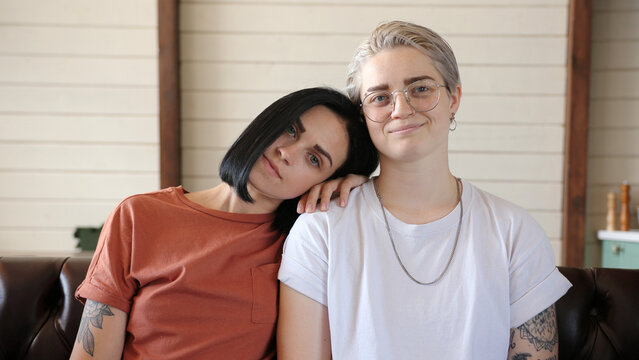 Serious lesbian couple with tattoos poses for camera